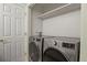 Efficient laundry room featuring a modern washer and dryer, and convenient overhead shelving for storage solutions at 1747 High Plains Ct, Superior, CO 80027