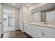 Primary bathroom featuring a large mirror, double sinks and white cabinets at 1385 Bloom St, Brighton, CO 80601