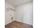 Small laundry room with wood-look floors, overhead shelving and modern hookups at 1385 Bloom St, Brighton, CO 80601