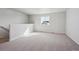 Bright loft area with neutral carpet, large window and access to the staircase at 1385 Bloom St, Brighton, CO 80601