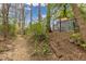 Backyard path leading to home with newer siding and a shed with trees overhead at 3230 Vance St, Wheat Ridge, CO 80033