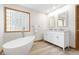Spa-like bathroom boasts a soaking tub, glass block window and double vanity at 3230 Vance St, Wheat Ridge, CO 80033