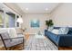 Inviting living room with hardwood floors, a comfy blue sofa, a stylish accent chair, and bright natural light at 3230 Vance St, Wheat Ridge, CO 80033