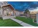 Inviting backyard with artificial turf, stone accents, deck, and string lights perfect for outdoor gatherings at 6234 Nautique Cir, Larkspur, CO 80118