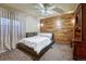 Modern bedroom with wood accent wall, platform bed, and side table at 6234 Nautique Cir, Larkspur, CO 80118