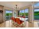 Bright dining room featuring modern light fixture, large windows and picturesque views of the lake and surrounding landscape at 6234 Nautique Cir, Larkspur, CO 80118