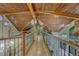 Second story hallway featuring wood ceilings, iron railings, and views of the living area at 6234 Nautique Cir, Larkspur, CO 80118