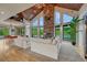 Bright living room featuring vaulted wood ceilings, stone fireplace, and expansive windows overlooking the lush backyard at 6234 Nautique Cir, Larkspur, CO 80118
