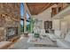 Open living room with a stone fireplace, wood ceilings, and large windows showcasing beautiful outdoor views at 6234 Nautique Cir, Larkspur, CO 80118