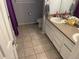 Bathroom with double sink vanity, tile floor, toilet and purple shower curtain at 14828 E Pacific Pl, Aurora, CO 80014
