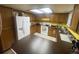 Well-lit kitchen features a full-sized refrigerator, plentiful wood cabinets, a window, and tiled floors at 14828 E Pacific Pl, Aurora, CO 80014