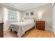 Cozy bedroom featuring hardwood floors, natural light from a window, and a comfortable bed at 2900 Clermont St, Denver, CO 80207