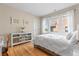 Bright bedroom with hardwood floors, natural light, and a white console table with decorative baskets at 2900 Clermont St, Denver, CO 80207