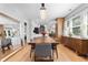 Spacious dining room with wood table, gray chairs, chandelier and open view to the kitchen and living room at 2900 Clermont St, Denver, CO 80207