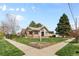Charming brick home with a well-manicured lawn and lush landscaping creates a welcoming curb appeal at 2900 Clermont St, Denver, CO 80207