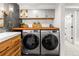Efficient laundry area with front-load washer and dryer, wood countertop, and cabinet storage at 2900 Clermont St, Denver, CO 80207