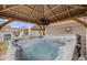 A hot tub under a gazebo with a TV and string lights provides an opportunity for relaxation at 17522 E Dewberry Dr, Parker, CO 80134