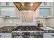 Close-up of a gas stove and copper range hood with custom cabinets and mosaic tile backsplash at 17522 E Dewberry Dr, Parker, CO 80134