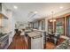 Open kitchen with stainless appliances, island, breakfast nook and living room with fireplace at 17522 E Dewberry Dr, Parker, CO 80134