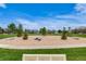 Park scene features a landscaped circular area with trees, rocks, and blue sky background at 17522 E Dewberry Dr, Parker, CO 80134