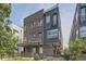 Modern townhome with brick and metal siding, offering a balcony and landscaped front yard at 1284 Stuart St, Denver, CO 80204