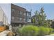 Modern townhouse with brick and metal siding, a small balcony, and lush green landscaping at 1284 Stuart St, Denver, CO 80204