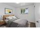 Bright bedroom features a window with blinds, a wood bed frame and a grey patterned rug at 4728 Dover St, Wheat Ridge, CO 80033