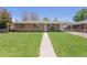 Charming single-story brick home with a well-manicured lawn and inviting walkway at 4728 Dover St, Wheat Ridge, CO 80033
