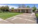Single story home featuring a brick facade, covered parking and mature landscaping at 4728 Dover St, Wheat Ridge, CO 80033
