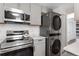 Updated kitchen with modern stainless steel appliances, light cabinets, and tile backsplash at 4728 Dover St, Wheat Ridge, CO 80033