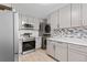 Updated kitchen featuring stainless steel appliances, gray cabinetry, and light countertops at 4728 Dover St, Wheat Ridge, CO 80033