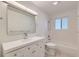 Bright bathroom featuring white vanity, shower-tub combo, and a large mirror at 1430 Lashley St, Longmont, CO 80504