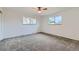 Well-lit bedroom featuring soft gray carpet, ceiling fan and dual windows at 1430 Lashley St, Longmont, CO 80504