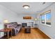 Cozy living room features a fireplace, hardwood floors, and a large window at 3811 E 138Th Pl, Thornton, CO 80602