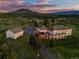 Scenic aerial view of backyard featuring pool, basketball court, and a beautifully landscaped yard at sunset at 3485 Park Ridge Rd, Sedalia, CO 80135