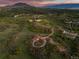 Scenic aerial shot of a red barn on a large lot with rolling hills, emphasizing the tranquil countryside setting at 3485 Park Ridge Rd, Sedalia, CO 80135