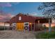 Charming red barn exterior with string lights, offering a rustic and inviting atmosphere at twilight at 3485 Park Ridge Rd, Sedalia, CO 80135
