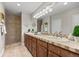 Well-lit bathroom features a double vanity, tiled countertops, and a glass-enclosed walk-in shower at 3485 Park Ridge Rd, Sedalia, CO 80135