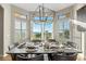Stylish dining room with a contemporary chandelier, large windows with shutters, and seating for eight guests at 3485 Park Ridge Rd, Sedalia, CO 80135
