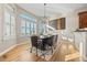 Bright dining room featuring large windows with shutters, a modern chandelier, and hardwood flooring at 3485 Park Ridge Rd, Sedalia, CO 80135