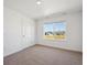 Cozy bedroom with neutral carpet, white walls, and a window providing a view of the outdoors at 1860 Chaffee Crest Dr, Berthoud, CO 80513