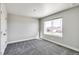 Bedroom with neutral walls, carpet flooring, and a large window for natural light at 1860 Chaffee Crest Dr, Berthoud, CO 80513