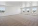 Large bonus room featuring neutral carpet and multiple windows providing natural light and neighborhood views at 1860 Chaffee Crest Dr, Berthoud, CO 80513