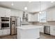 Contemporary kitchen featuring stainless steel appliances, a center island, and white cabinets at 1860 Chaffee Crest Dr, Berthoud, CO 80513