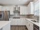 Well-equipped kitchen with stainless steel appliances, modern countertops, and light gray backsplash at 1860 Chaffee Crest Dr, Berthoud, CO 80513