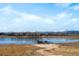 Scenic lake view features a tranquil wooden dock and walking access amidst a serene community setting with mountains at 1860 Chaffee Crest Dr, Berthoud, CO 80513