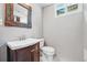 Small bathroom with a decorative mirror, wood vanity, and neutral walls at 2435 Creighton Dr, Golden, CO 80401