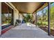 Covered backyard porch with outdoor furniture and a view of the lush landscaping at 2435 Creighton Dr, Golden, CO 80401