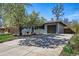 Residential home featuring an attached garage, driveway, landscaping, and a beautiful flowering tree at 2435 Creighton Dr, Golden, CO 80401