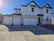 Modern two-story home with white siding, brick accents, and a spacious three-car garage at 5685 Farrier Pt, Castle Rock, CO 80104